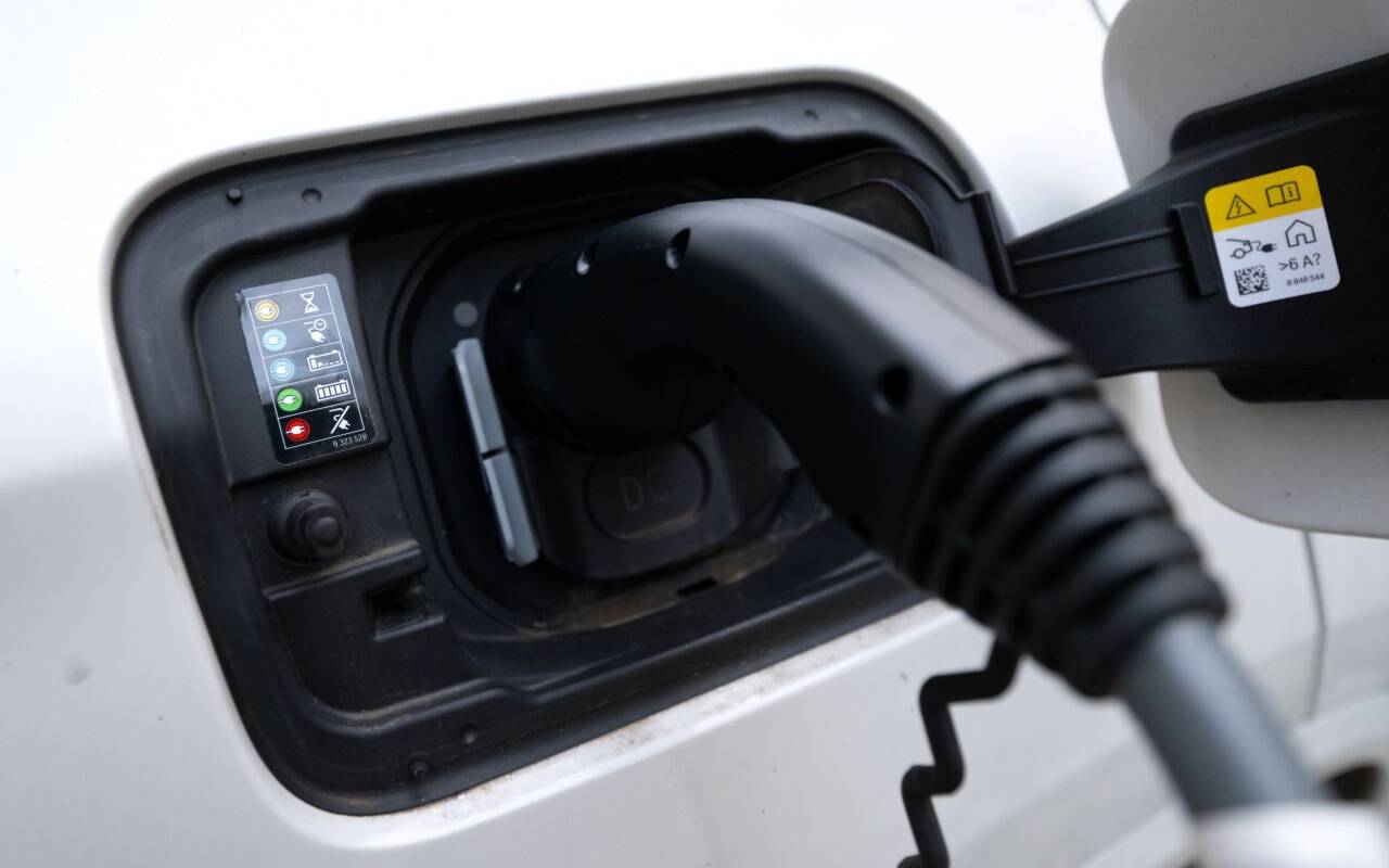 Der Stecker einer Ladesäule ist beim Ladevorgang an einem Auto zu sehen.
