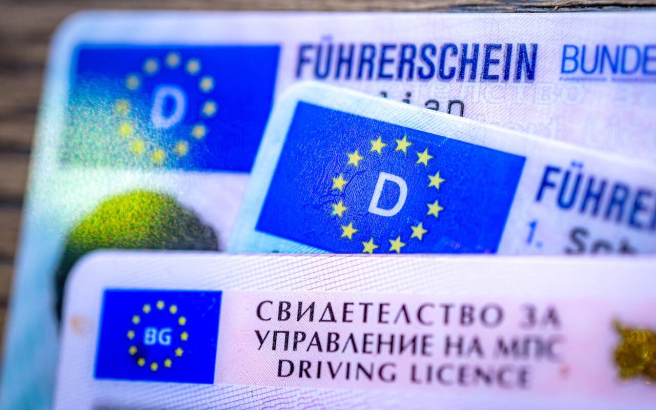 Ein bulgarischer und zwei deutsche Führerscheine liegen auf einem Tisch.