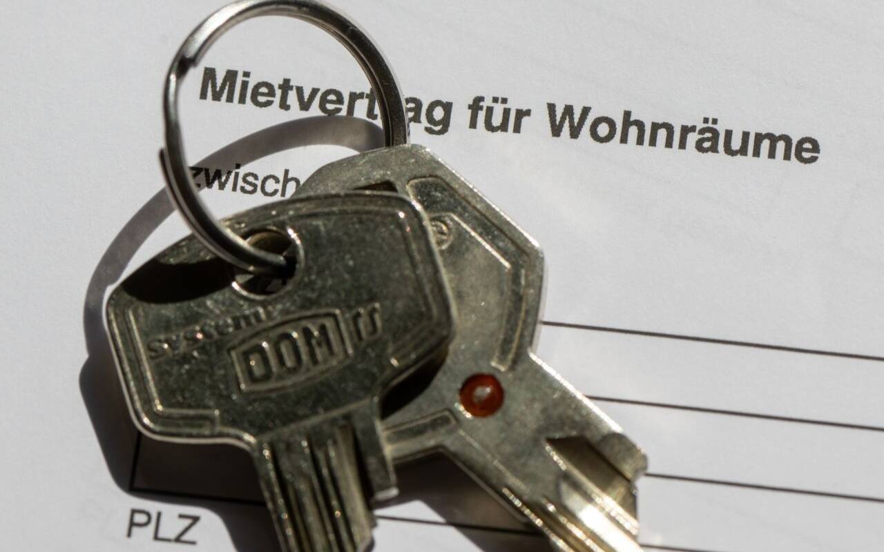 Ein Wohnungsschlüssel liegt auf einem Mietvertrag für eine Wohnung.