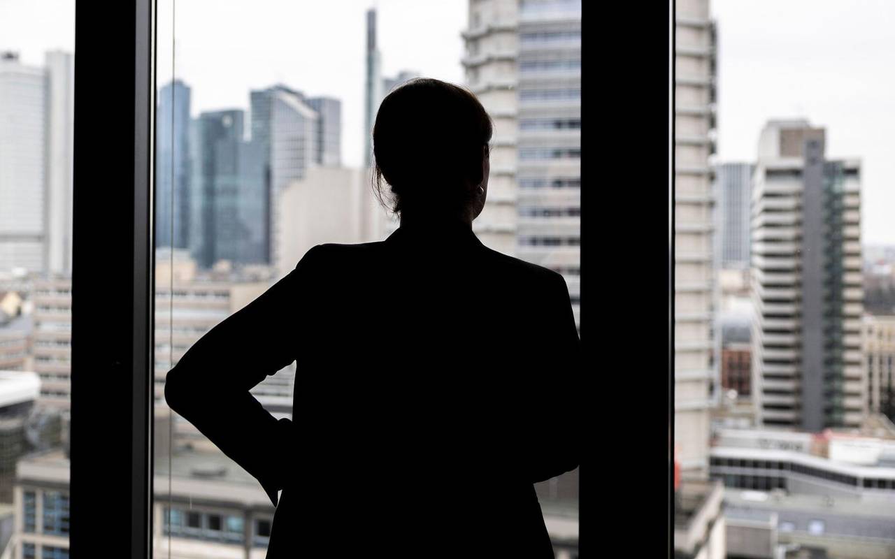 Frau schaut aus einem Bürofenster