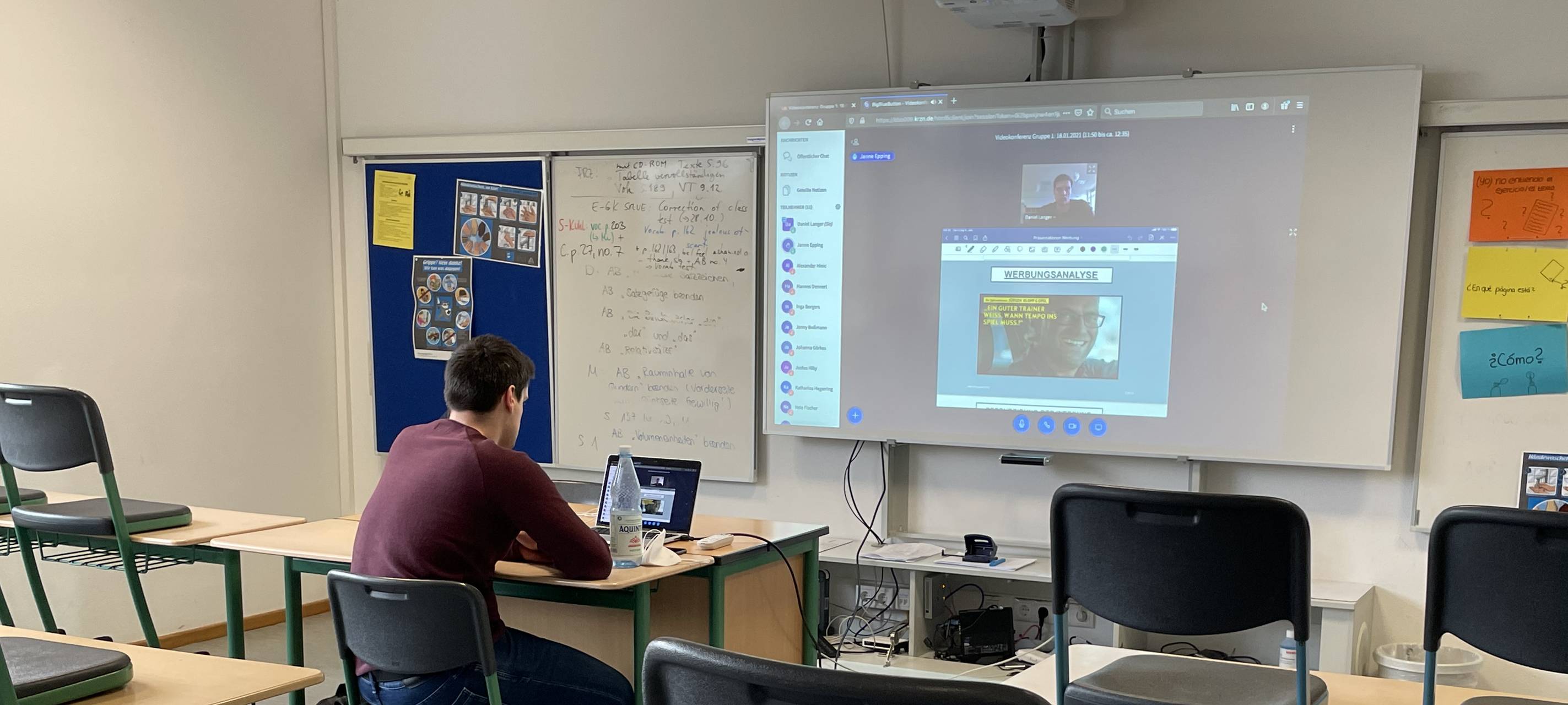 Homeschooling in der Coronazeit. Der Lehrer sitzt alleine im Klassenraum, die Schüler sitzen zuhause.