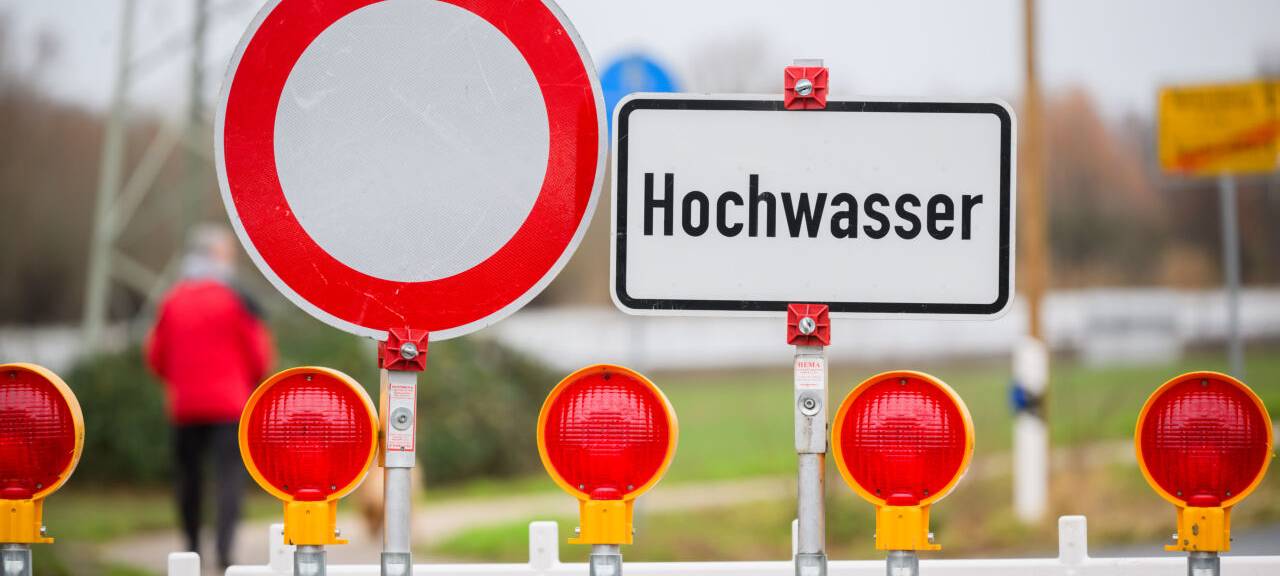 Ein Warnschild "Hochwasser" steht an einer Straßensperre an der Leinemasch in der südlichen Region Hannover.
