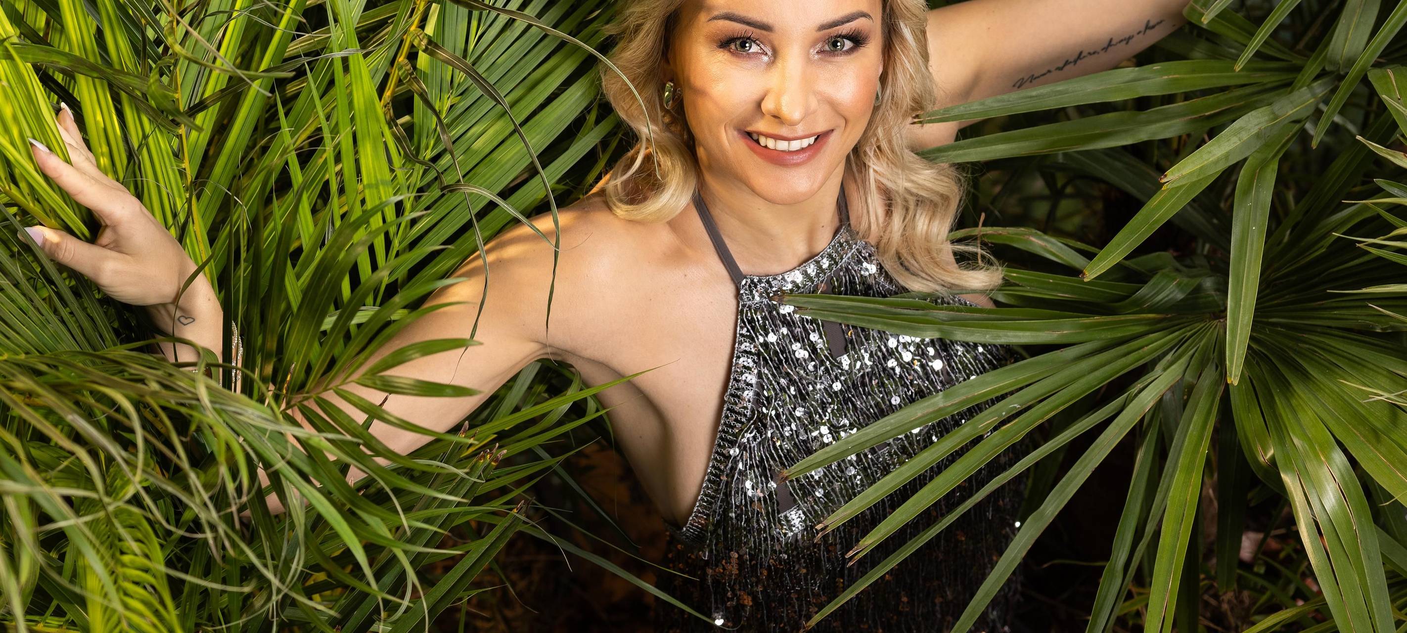 Anna-Carina Woitschak schaut lächelnd in die Kamera - im Rahmen des RTL-Dschungelcamps.