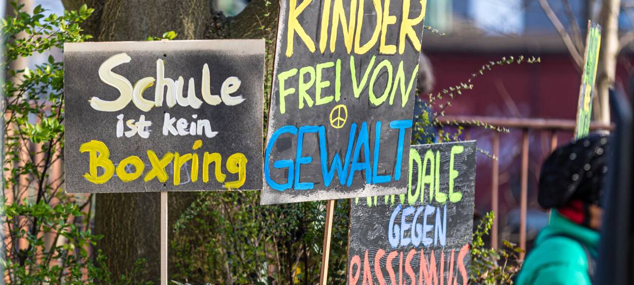 "Schule ist kein Boxring" und "Kinder frei von Gewalt" steht auf Schildern während einer Demonstration unter dem Motto "Kinder brauchen Sicherheit – Schule ohne Rassismus" vor dem Schulamt Cottbus