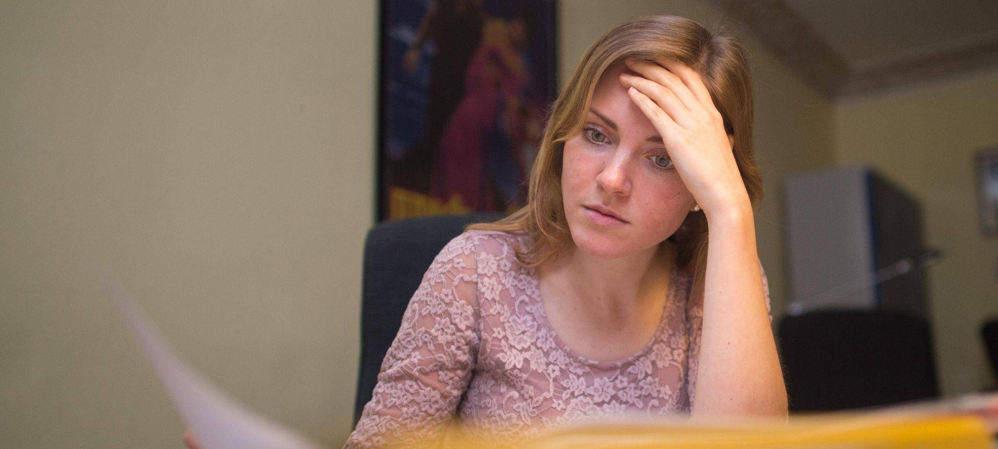 Frau sitzt konzentriert am Schreibtisch