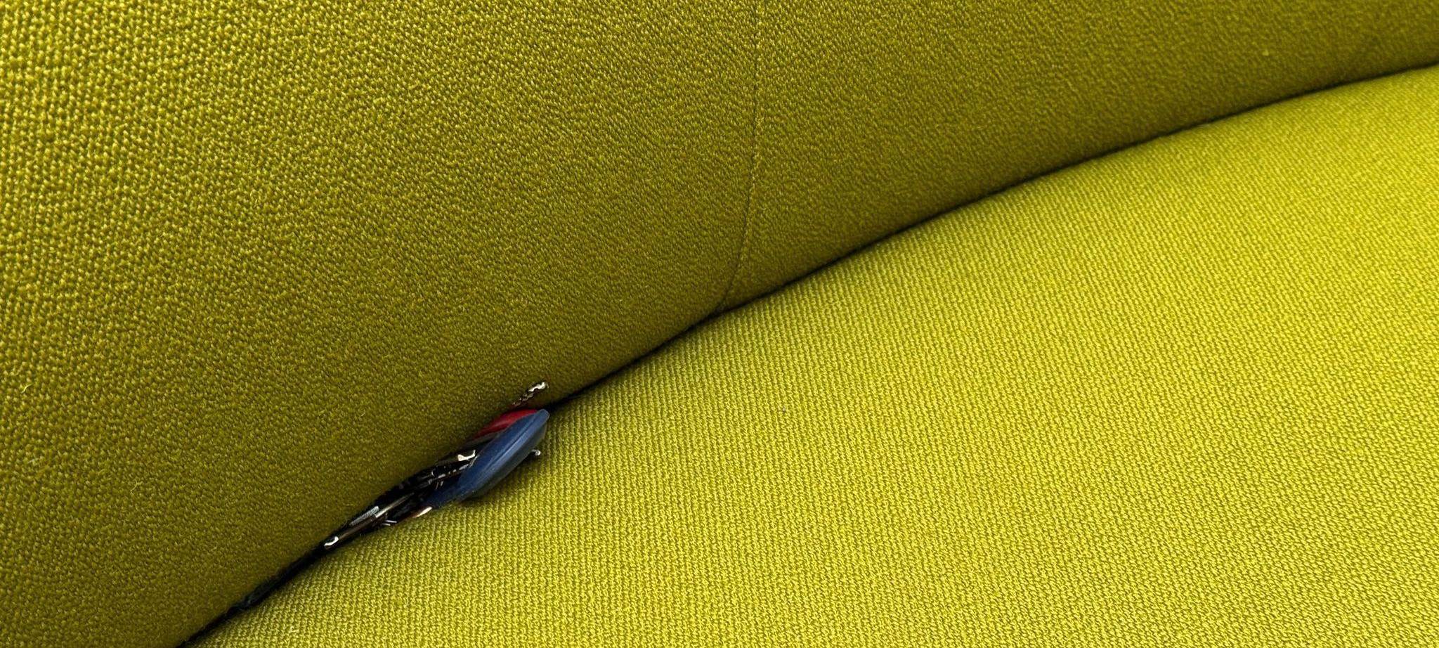 Schlüssel mit einem Airtag liegt in einer Sofaritze