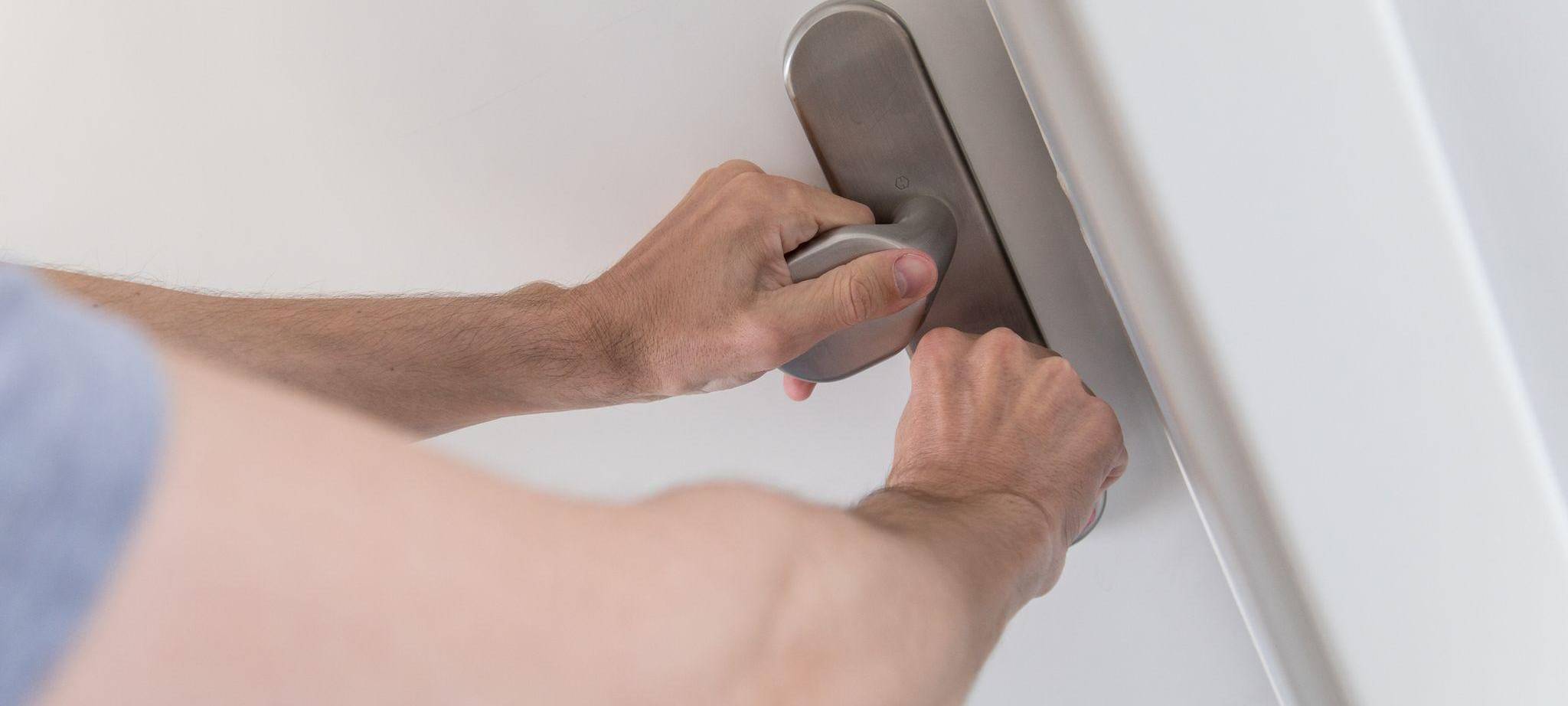 Mann schließt eine Wohnungstür ab