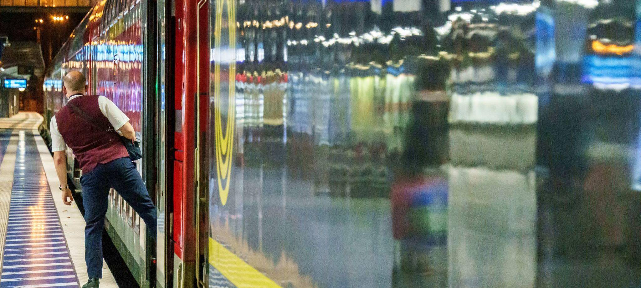 Ein Zugbegleiter blickt kurz vor Abfahrt zum Lokführer.