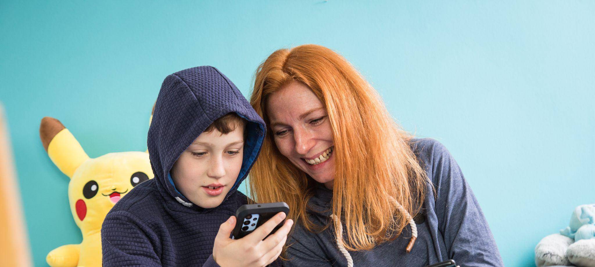 Mutter und Sohn mit Smartphones