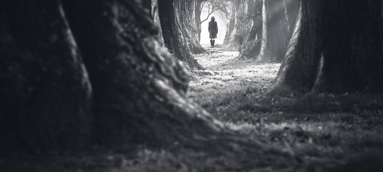 Eine Frau läuft einen einsamen Weg entlang (Symbolbild).