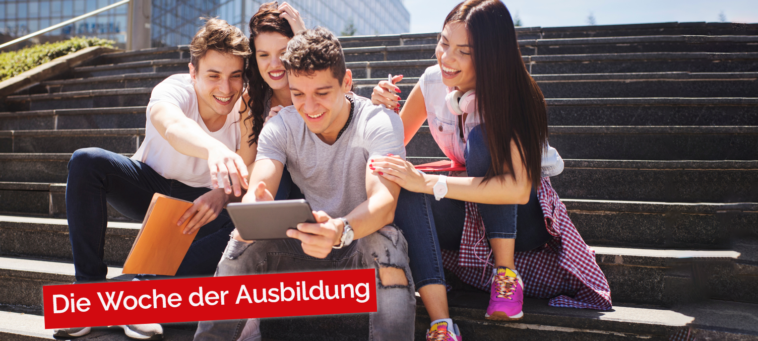 Junge Erwachsene mit Tablett auf Treppe vor einer Uni