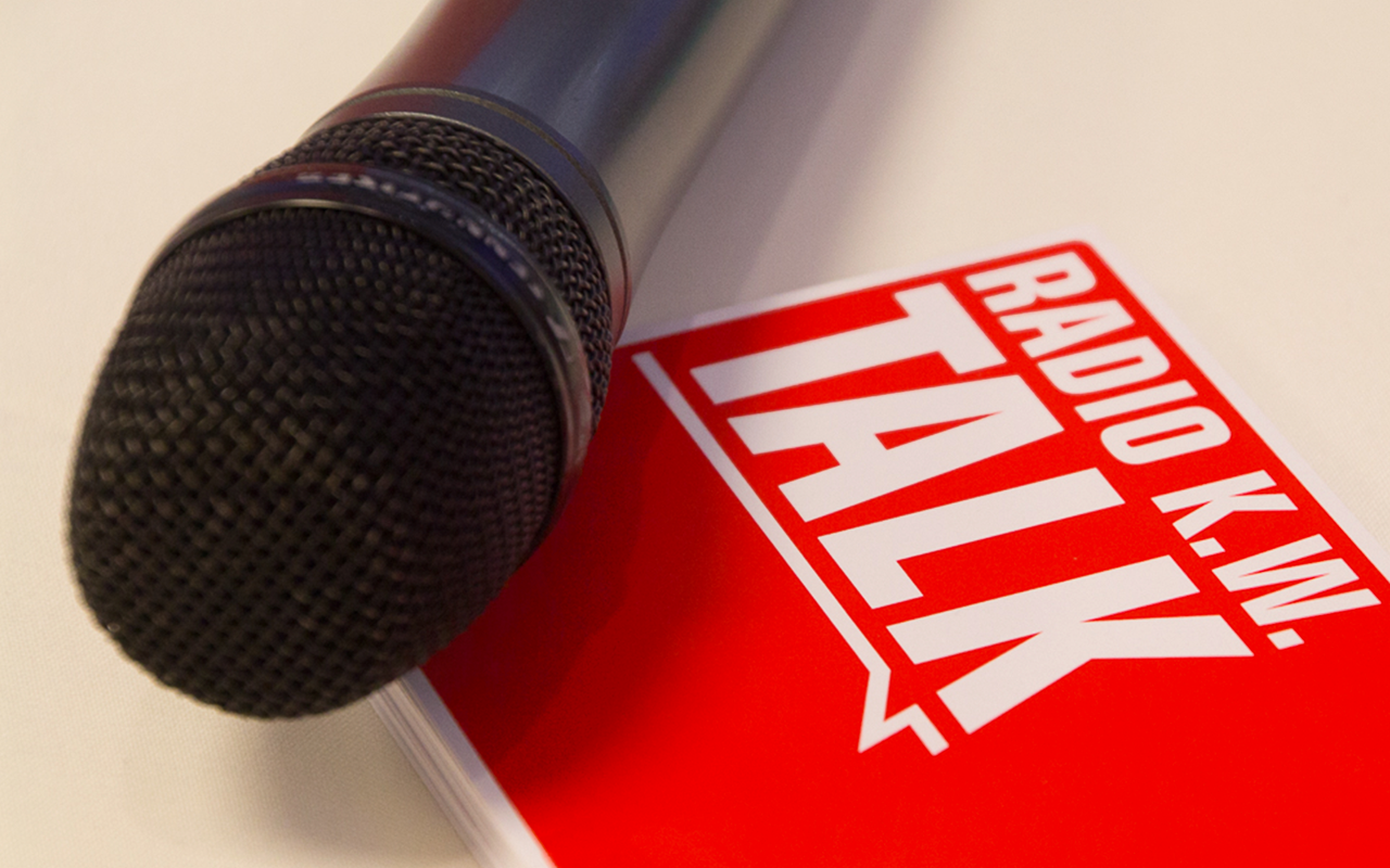 Ein Mikrofon mit dem Schriftzug "Radio K.W. Talk in" liegt auf einem Tisch.